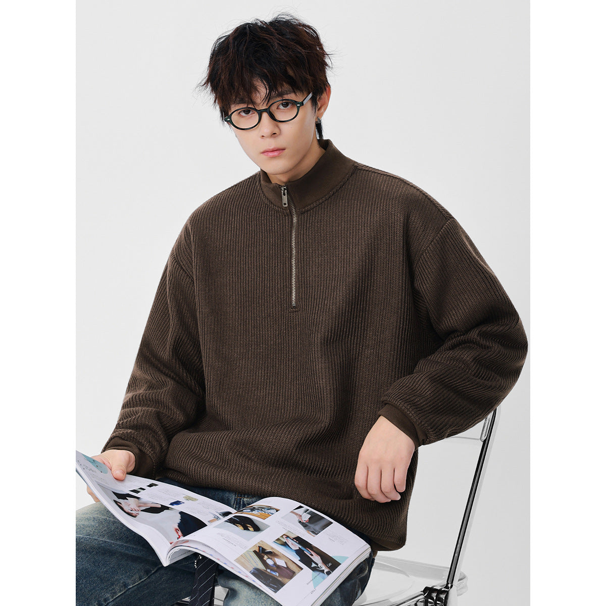 Seated model wearing a dark brown textured half-zip pullover with a stand collar.