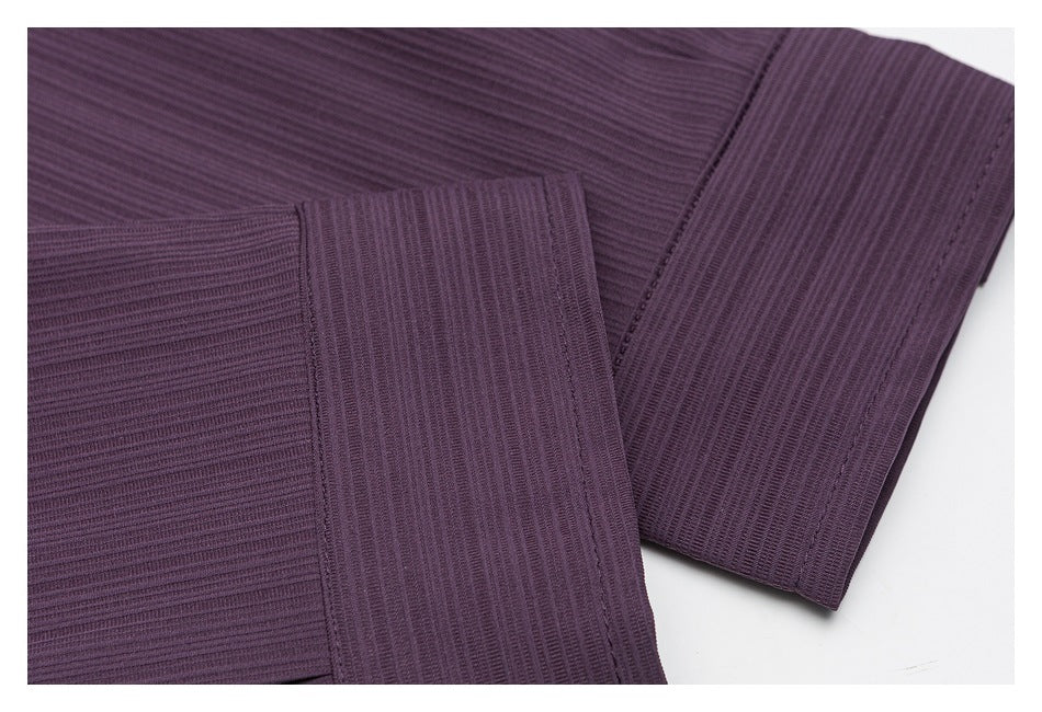 Close-up of the plum-purple shirt's long sleeve and buttoned cuff, showing its ribbed texture.