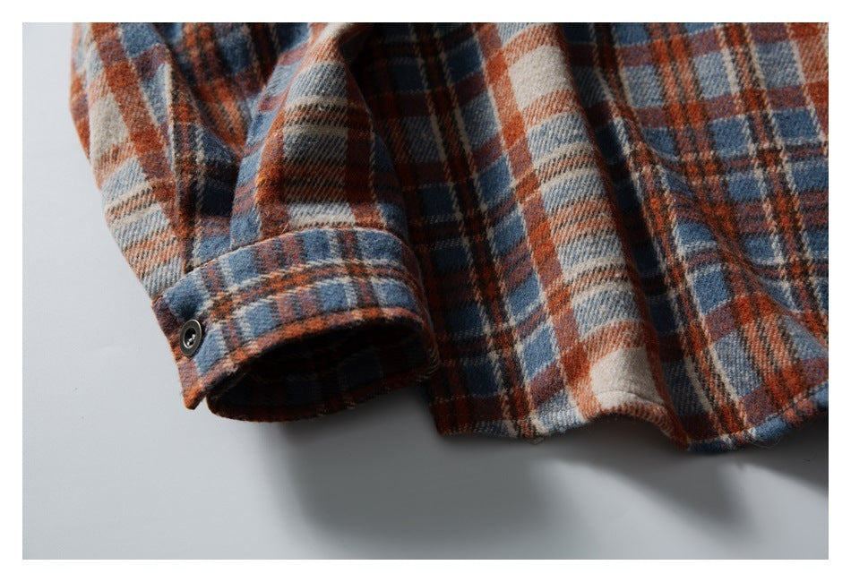 Close-up of the plaid shirt's cuff, hem, and button detail.
