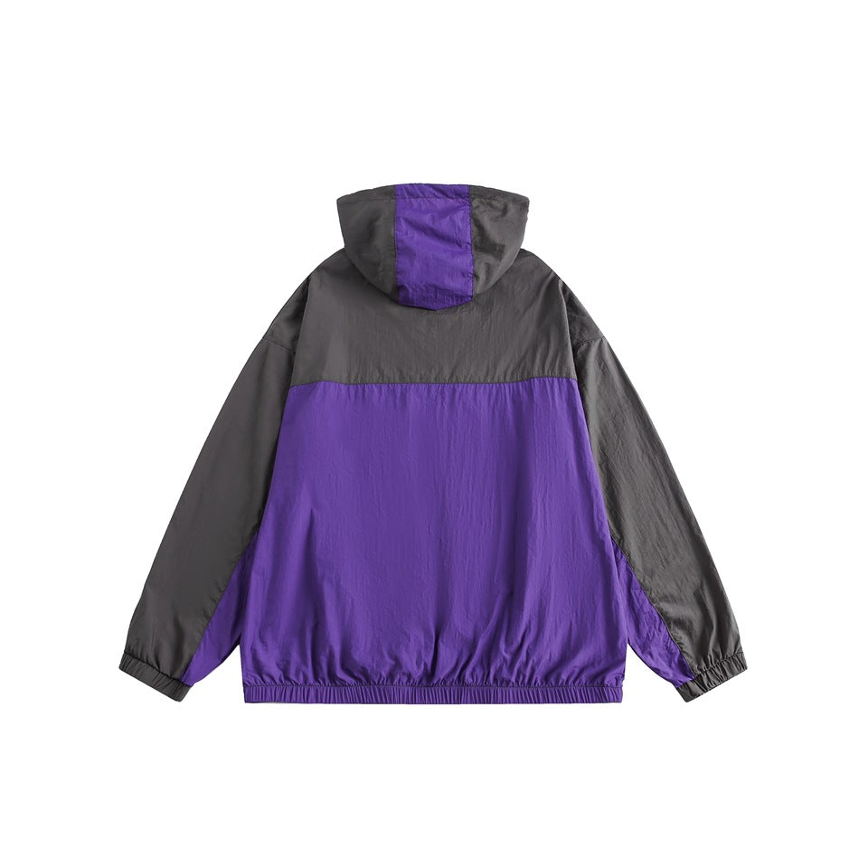 Back view of a charcoal and purple color-block hooded jacket with elastic cuffs and hem.