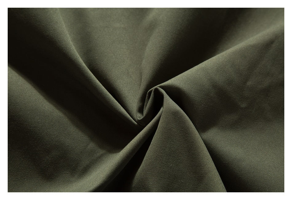 Close-up of olive fabric arranged in folds, showing its surface and texture.