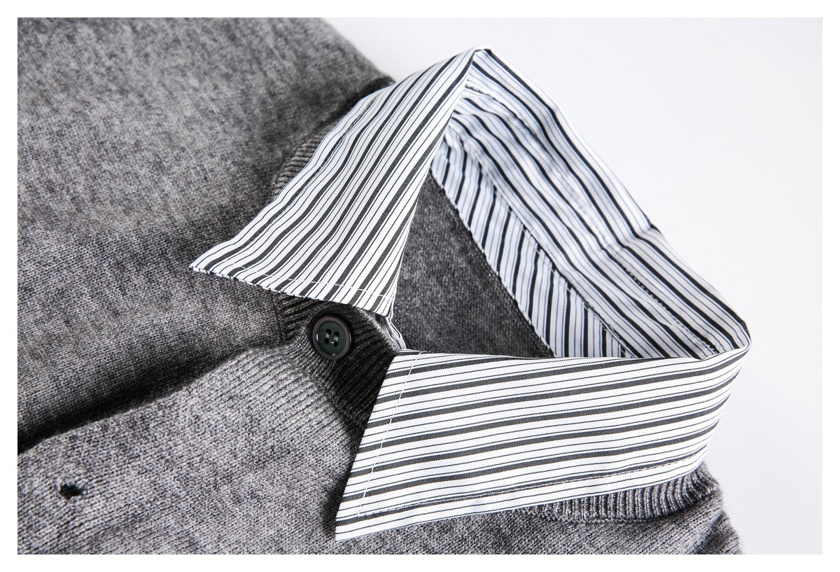 Close-up of a gray sweater's striped shirt collar and dark button.