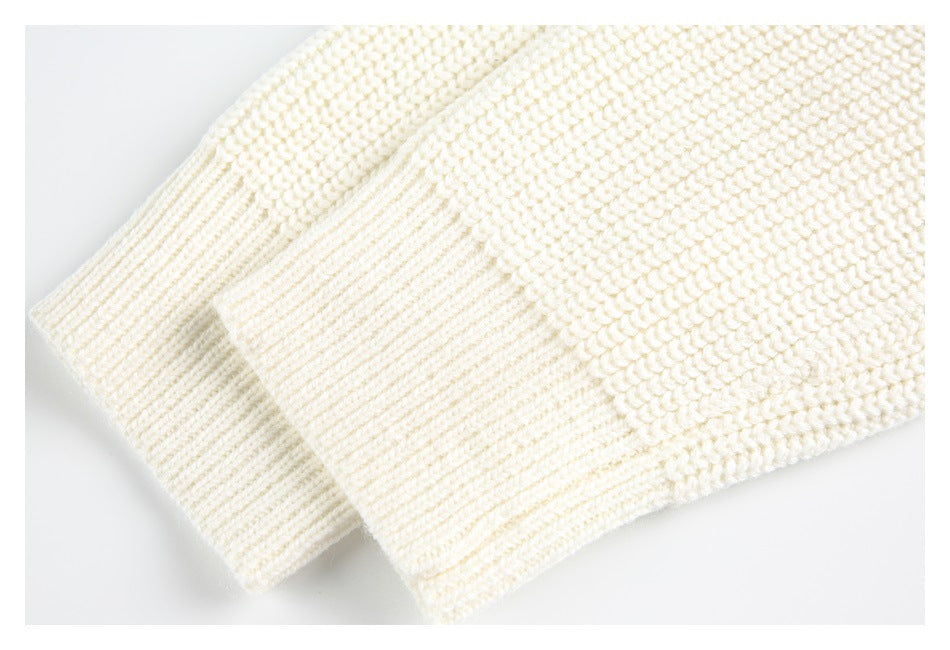 Close-up of the ivory knit garment's ribbed edge beside a chunky textured knit section.