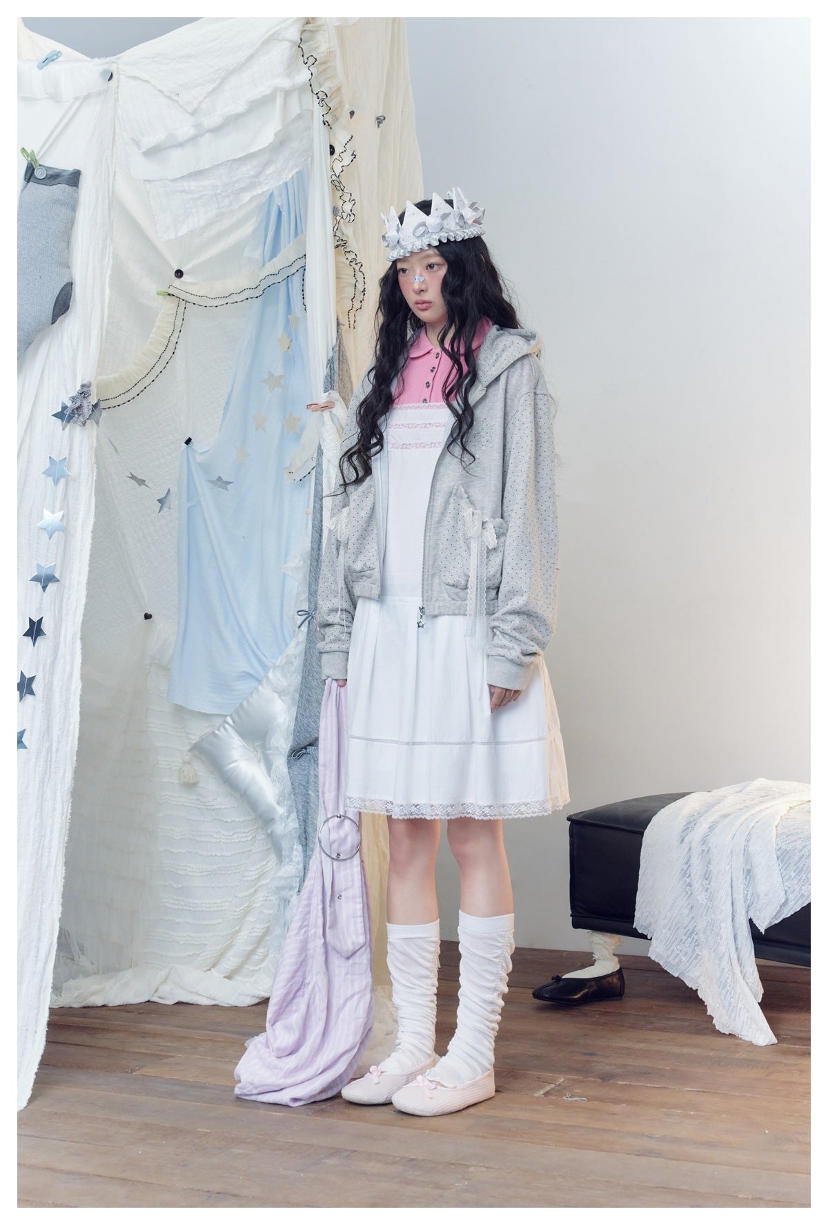 Model in the gray zip hoodie with lace bow pockets, three-quarter view, over a white dress and pink collar