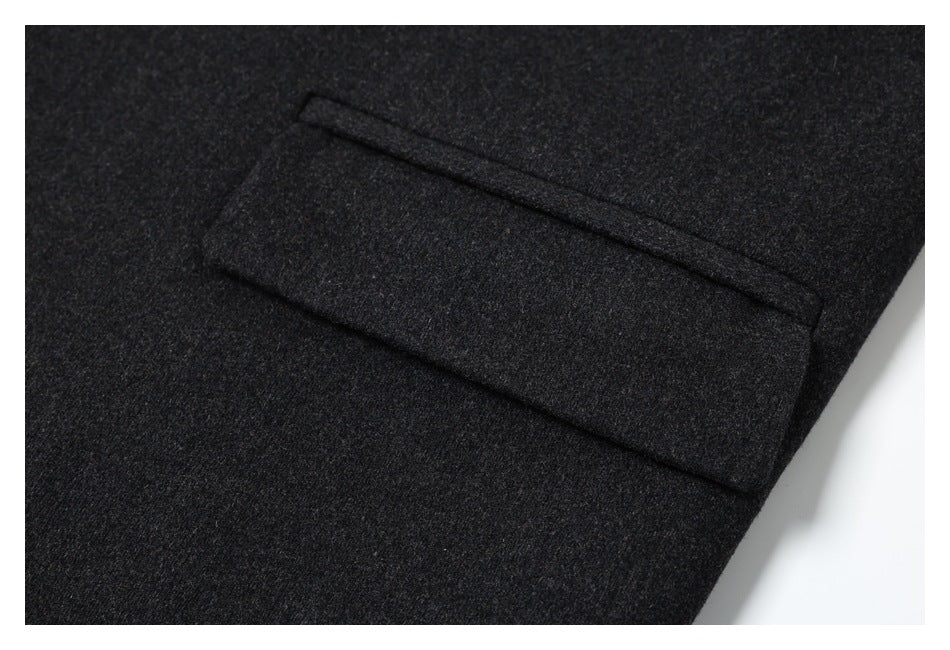 Close-up of a welt pocket on dark charcoal fabric.