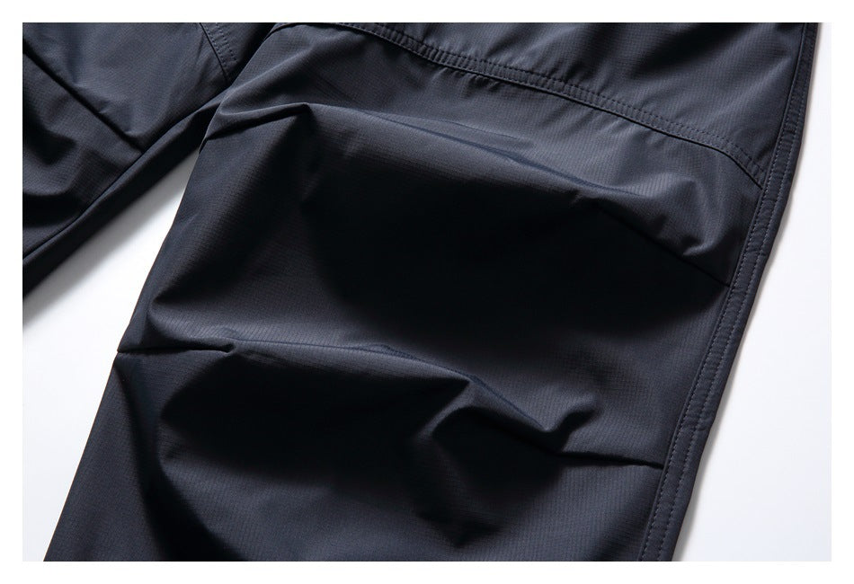 Close-up of dark navy trousers showing stitched seams and a subtle grid texture.
