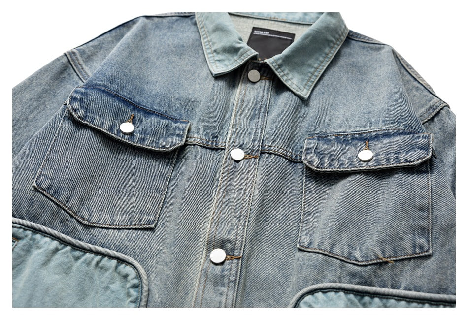 Flat-lay front view of a light blue washed denim jacket with pointed collar, metal buttons, and two flap chest pockets.