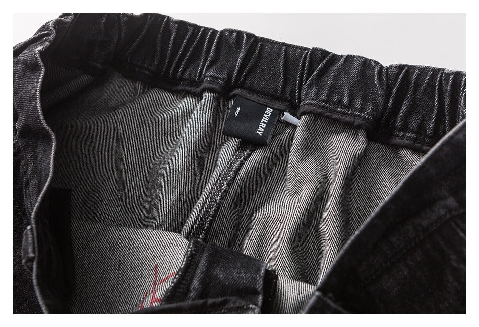 Close-up of the inside waistband and gray lining of black pants, with a black DEVILRAY label.