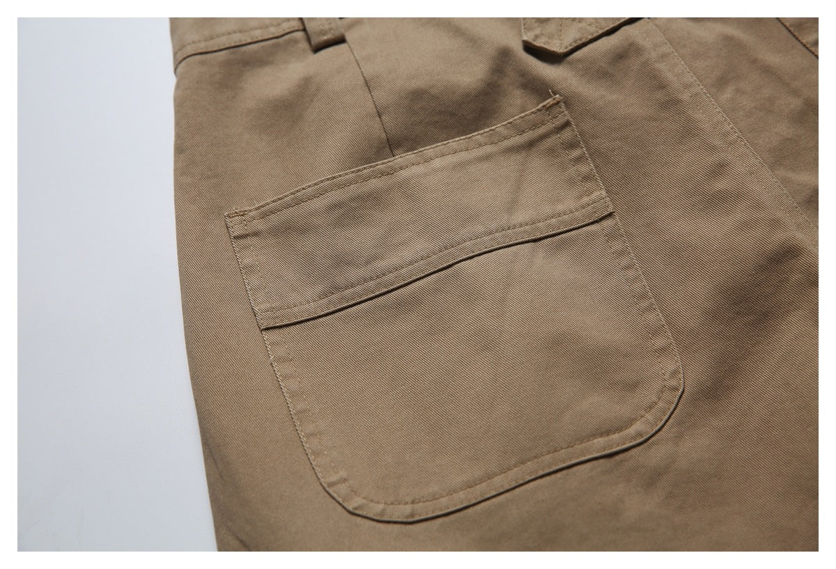 Close-up of a large rectangular patch pocket with a horizontal stitched detail on brown trousers.