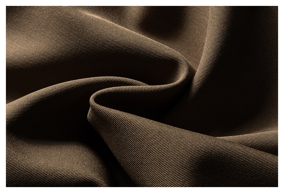 Close-up of brown fabric draped into folds, showing its fine diagonal ribbed texture.