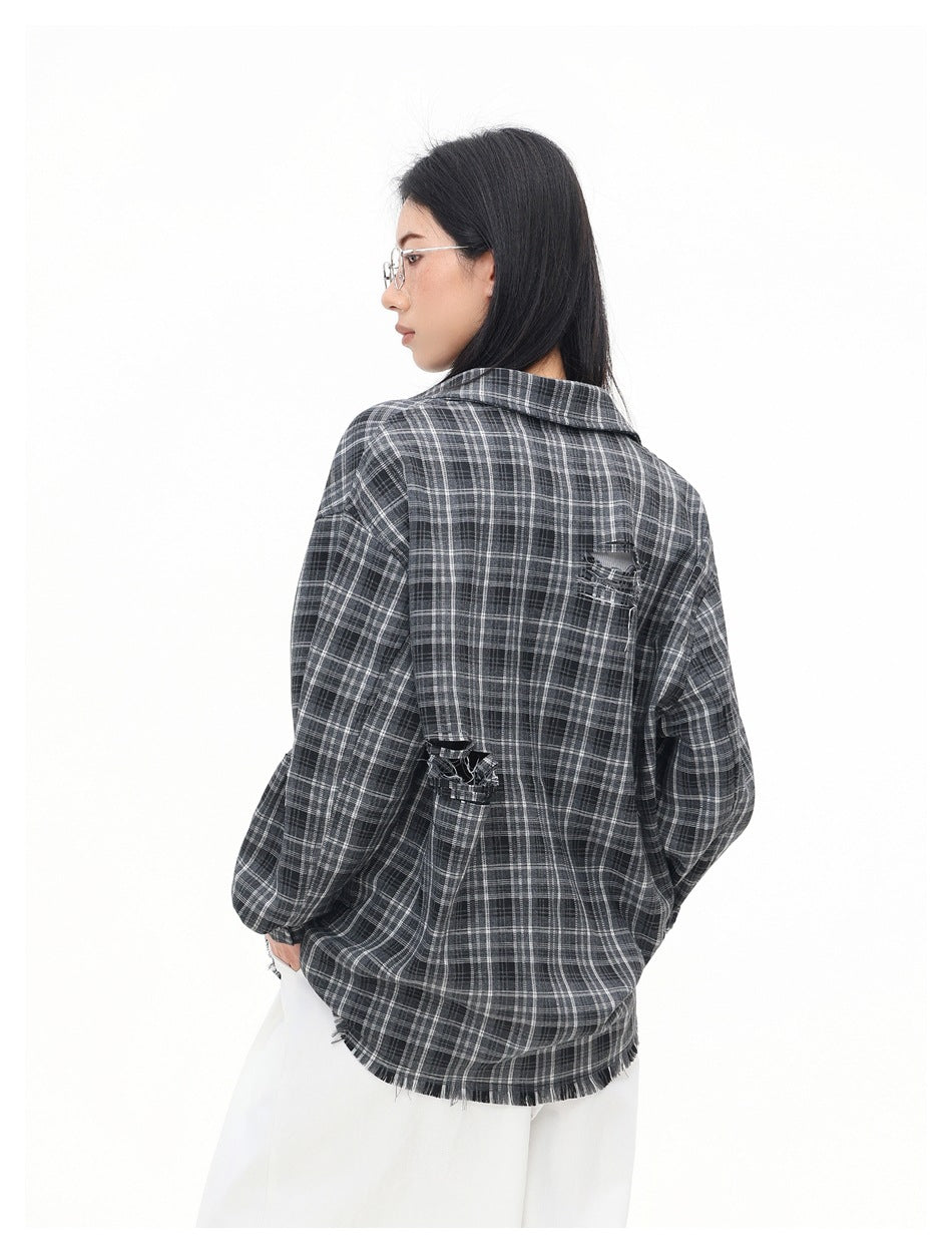 Rear three-quarter view of a model wearing an oversized charcoal gray plaid shirt with distressed accents and a frayed hem.
