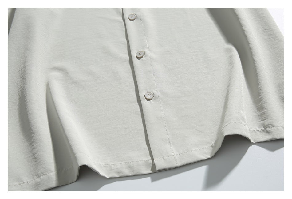 Close-up of the light ivory shirt front, showing its button placket and lower hem.