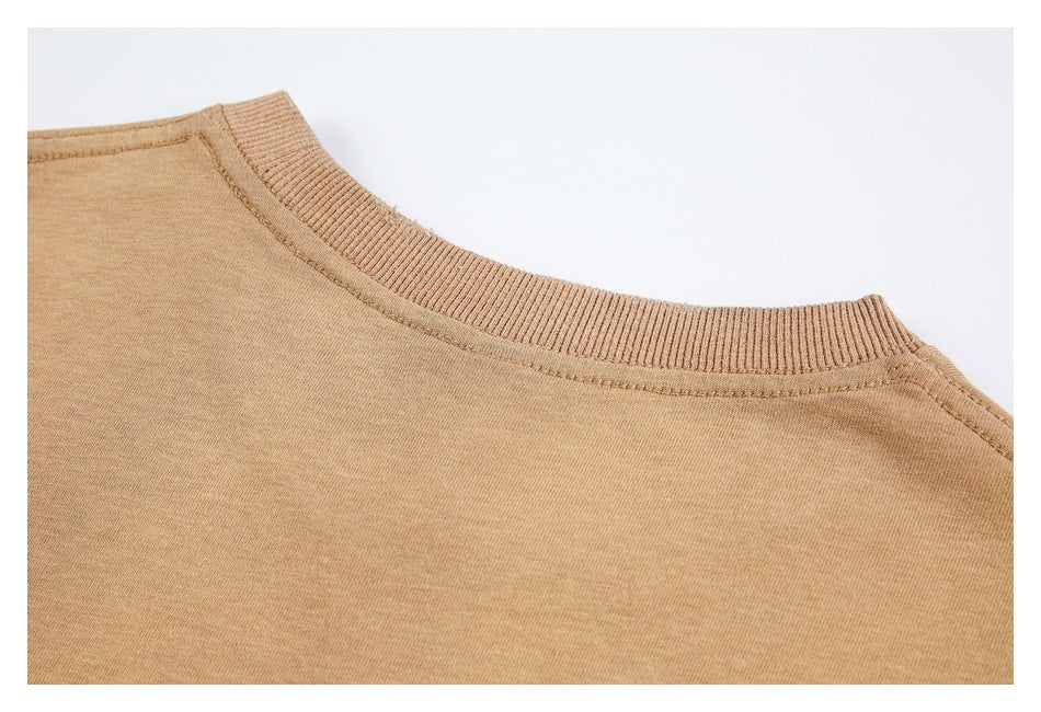 Close-up of a tan crew neckline with a ribbed collar and visible stitching.