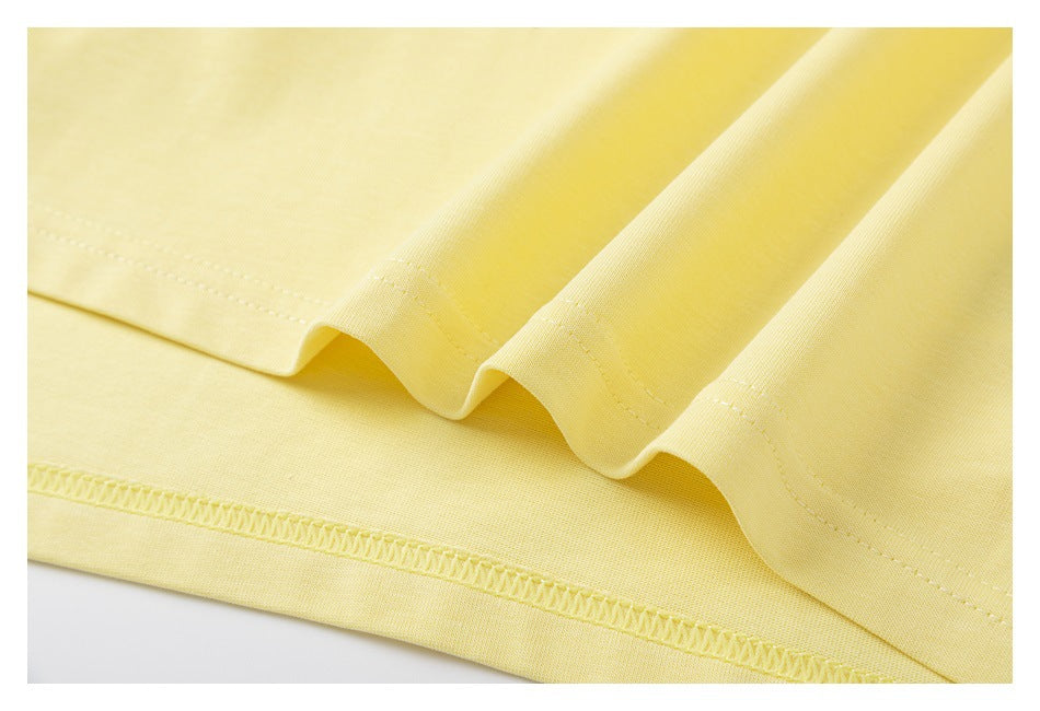Close-up of the pale yellow T-shirt's stitched lower hem and overlocked inside seam.