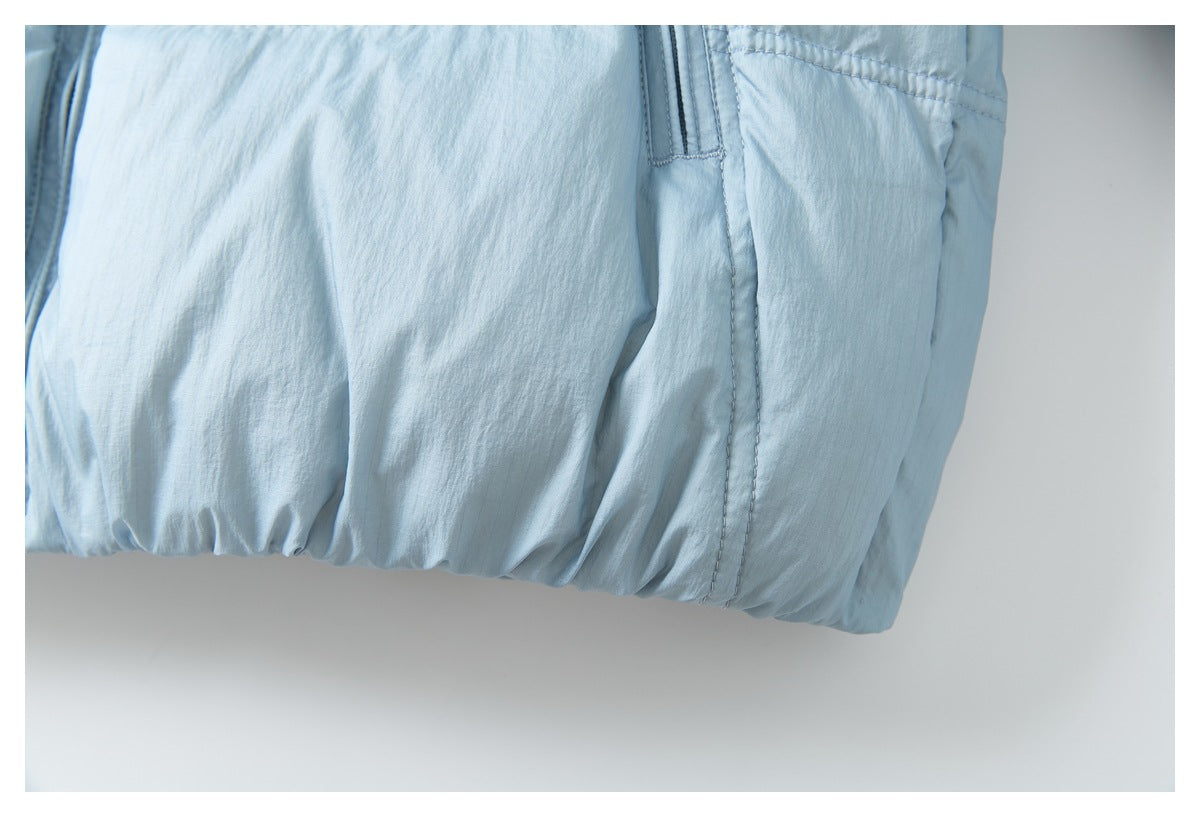 Close-up of the pale blue jacket's lower front, showing a gathered hem and stitched pocket edge.
