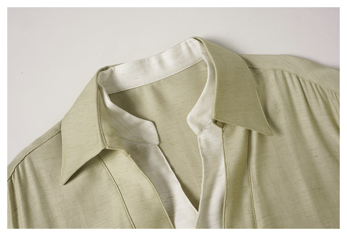 Close-up of a pale beige shirt's pointed collar and contrasting light inner placket.