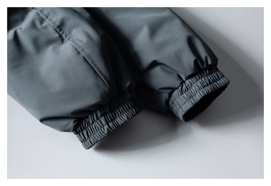 Close-up of both slate-gray jacket sleeves ending in gathered elastic cuffs.