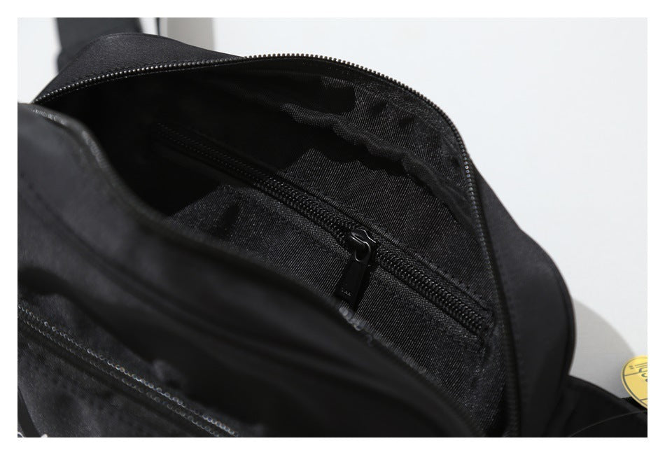 Open black bag showing its lined interior, main compartment, and an internal zip pocket.