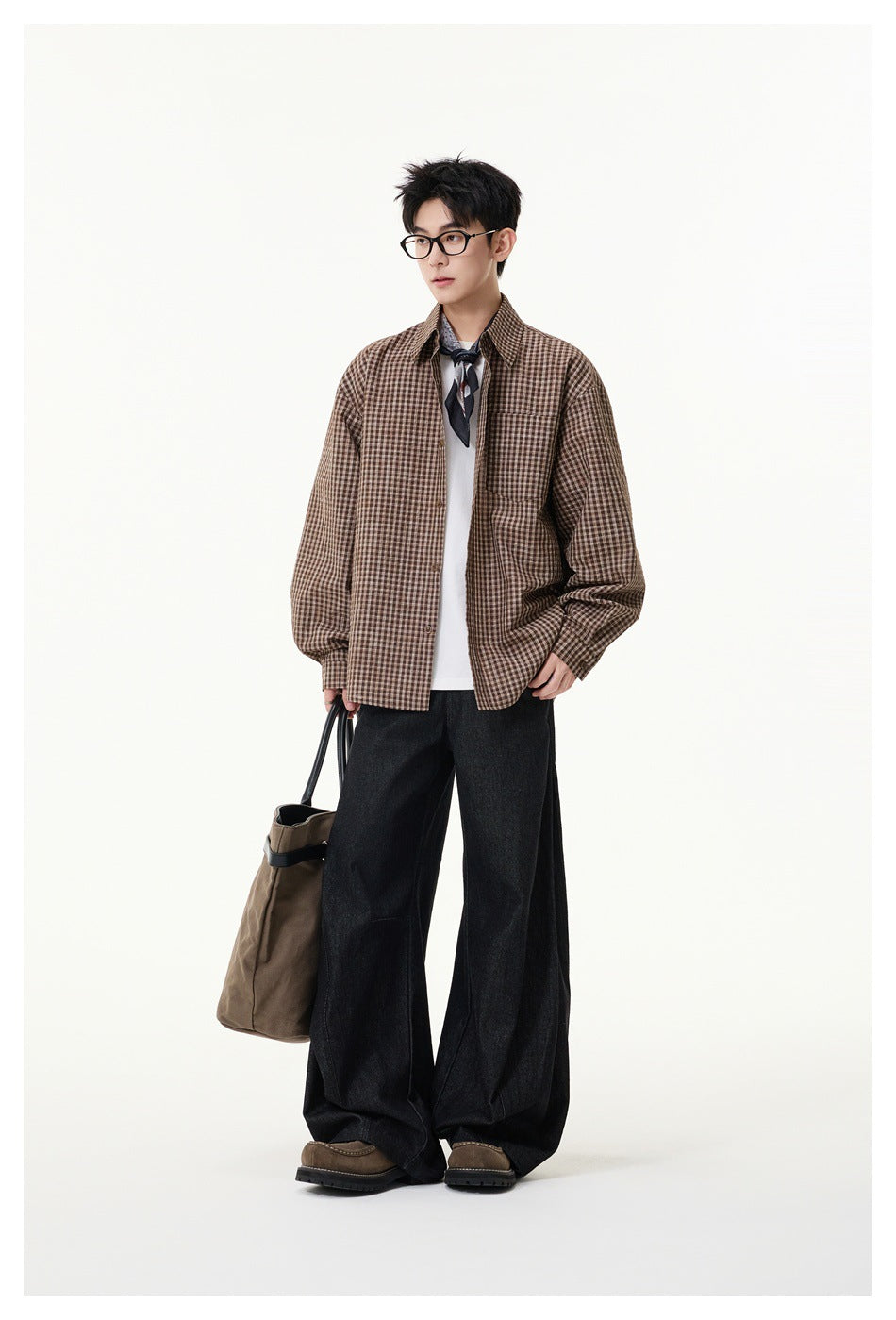 Full-length model wearing a brown checked button-up shirt over a white tee with wide black trousers.