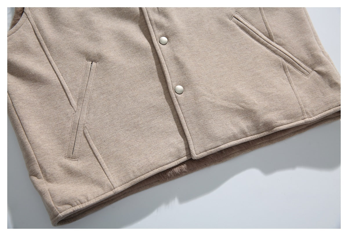 Cropped front view of a beige jacket laid flat, showing snap closures, angled pockets, and brown lining at the hem.