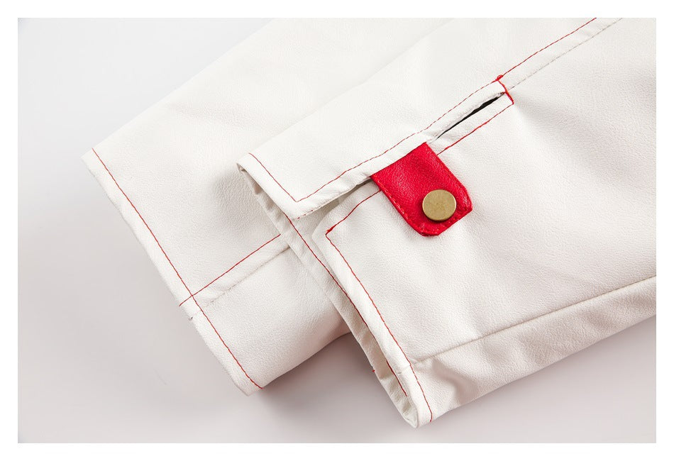 Close-up of a white jacket cuff with red stitching and a red tab fastened by a gold-tone snap.