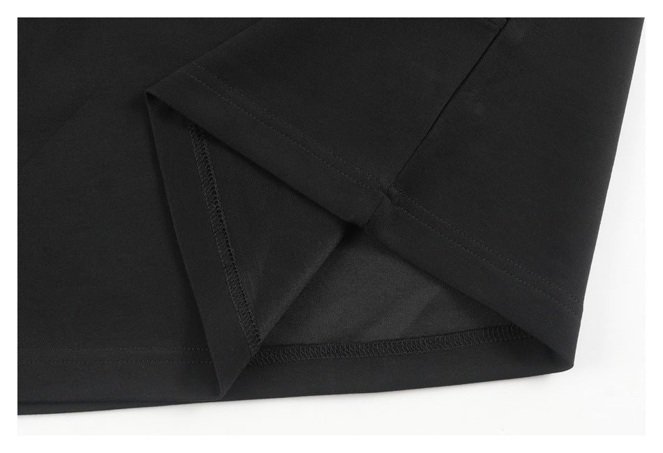 Close-up of a black garment's turned hem and interior seam stitching.