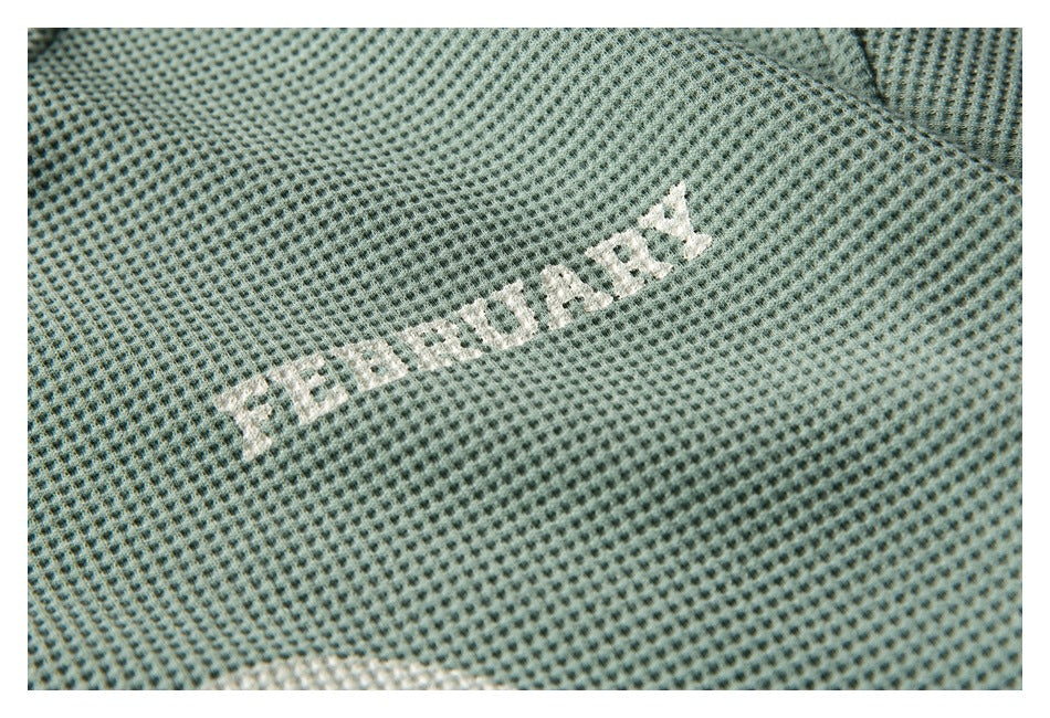 Close-up of sage-green textured fabric with a small distressed white printed word.