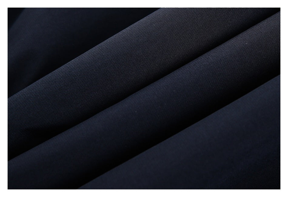 Close-up of dark navy fabric draped in folds, showing its surface texture.