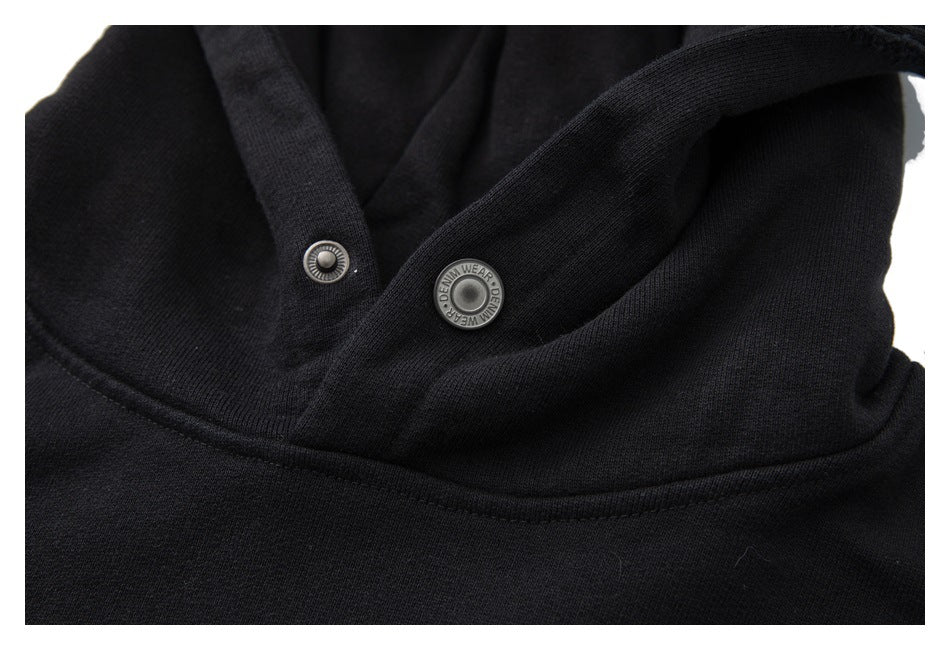 Close-up of the black hood's snap closure and neckline; the snap has small English lettering.