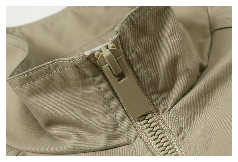 Close-up of a beige garment's zipper, stitching, and surrounding fabric.