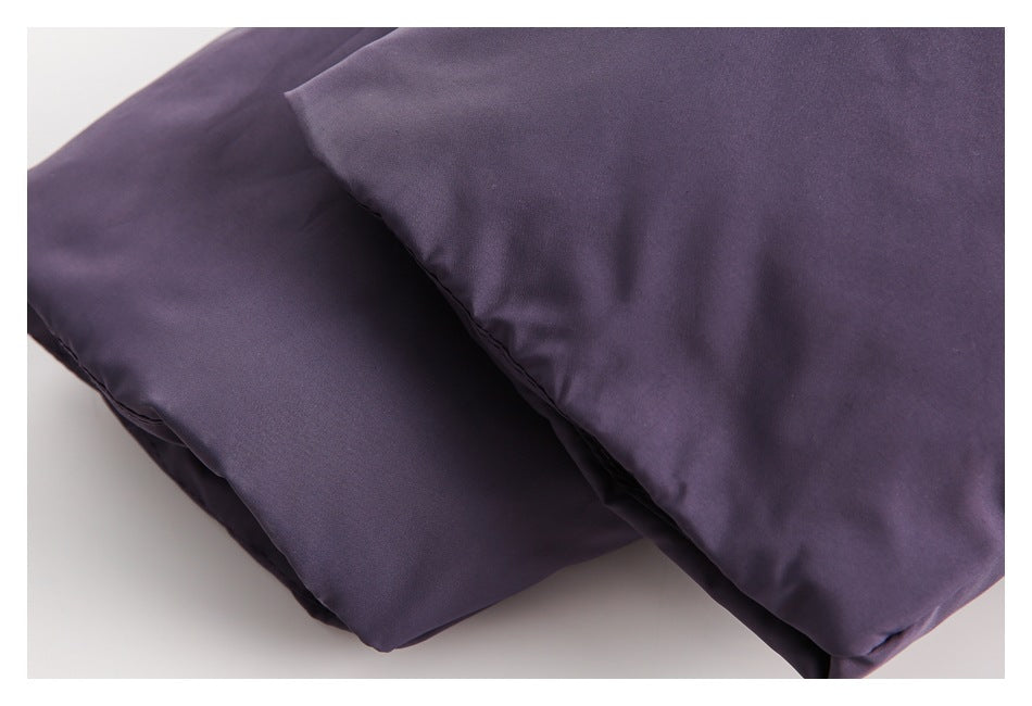 Close-up of overlapping purple garment panels with a stitched edge.