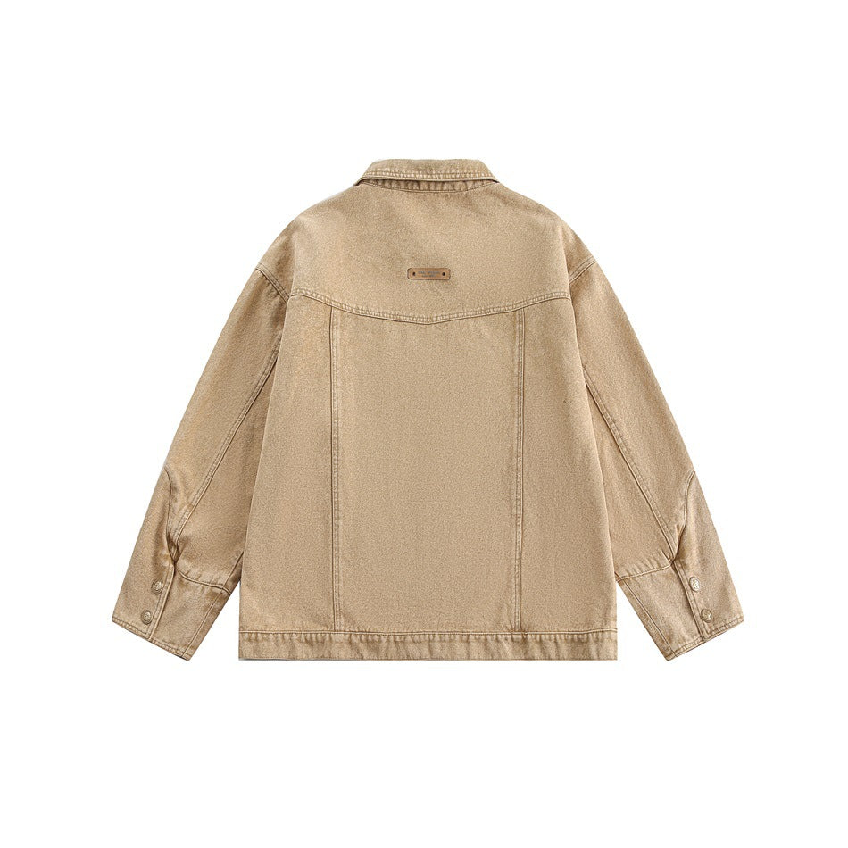 Back view of a tan jacket with a pointed collar, long sleeves, buttoned cuffs, and a small label near the neckline.