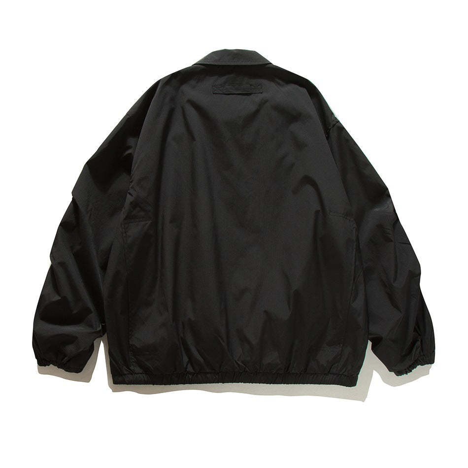 Back view of a black collared jacket with long sleeves, elastic cuffs, and a gathered hem.