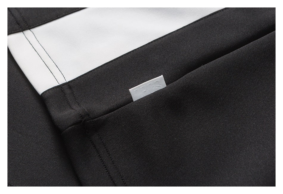 Close-up of black fabric seams beside a white panel and a small sewn label.