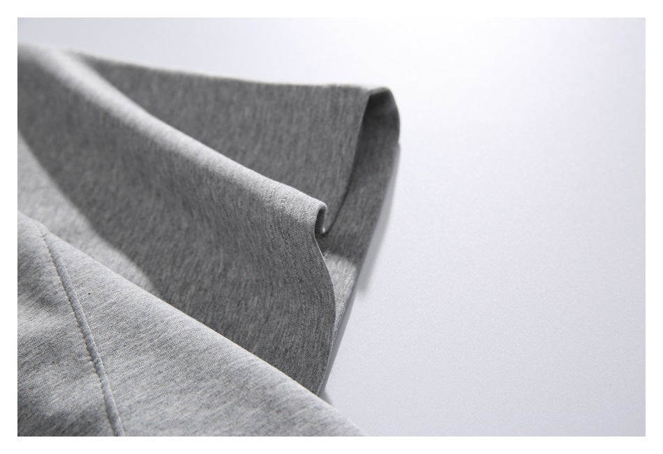 Close-up of the folded sleeve edge and seam on a heather gray sweatshirt.