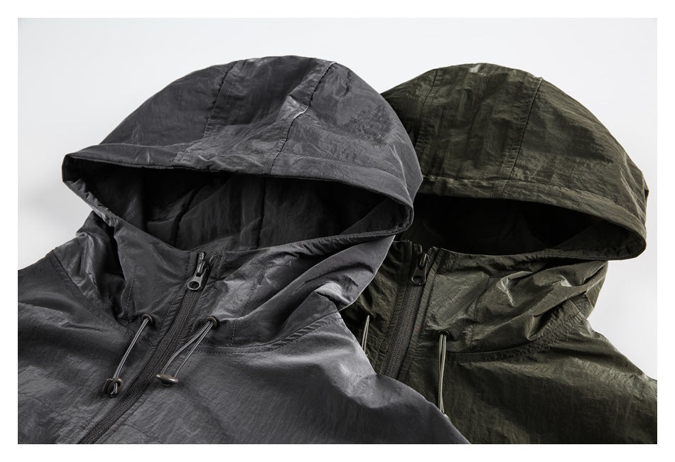 Two hooded zip jackets shown together in charcoal gray and dark olive, with drawcords at the collars.