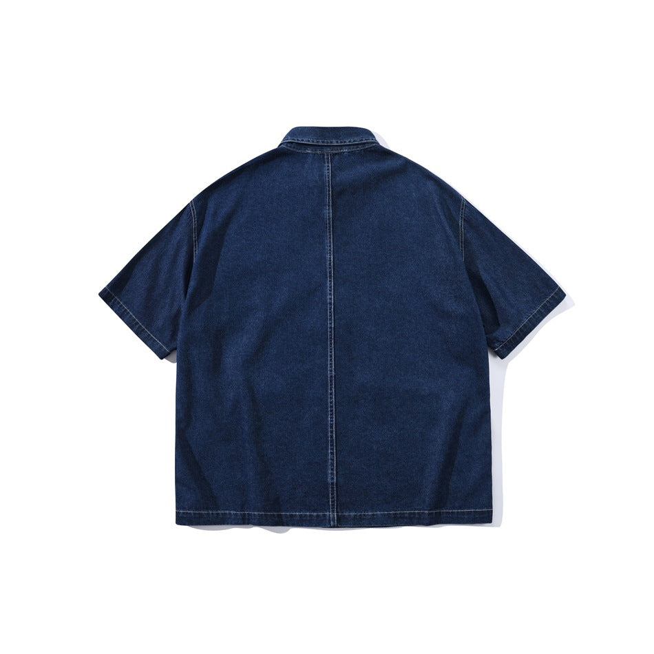 Back view of dark blue short-sleeve denim-look shirt with center back seam and contrast stitching, flat lay