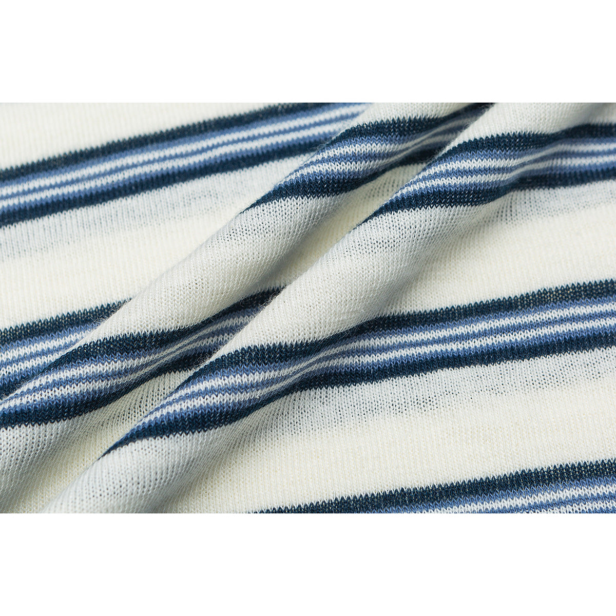 Close-up of ivory knit fabric with narrow navy stripes, shown draped to reveal its texture.