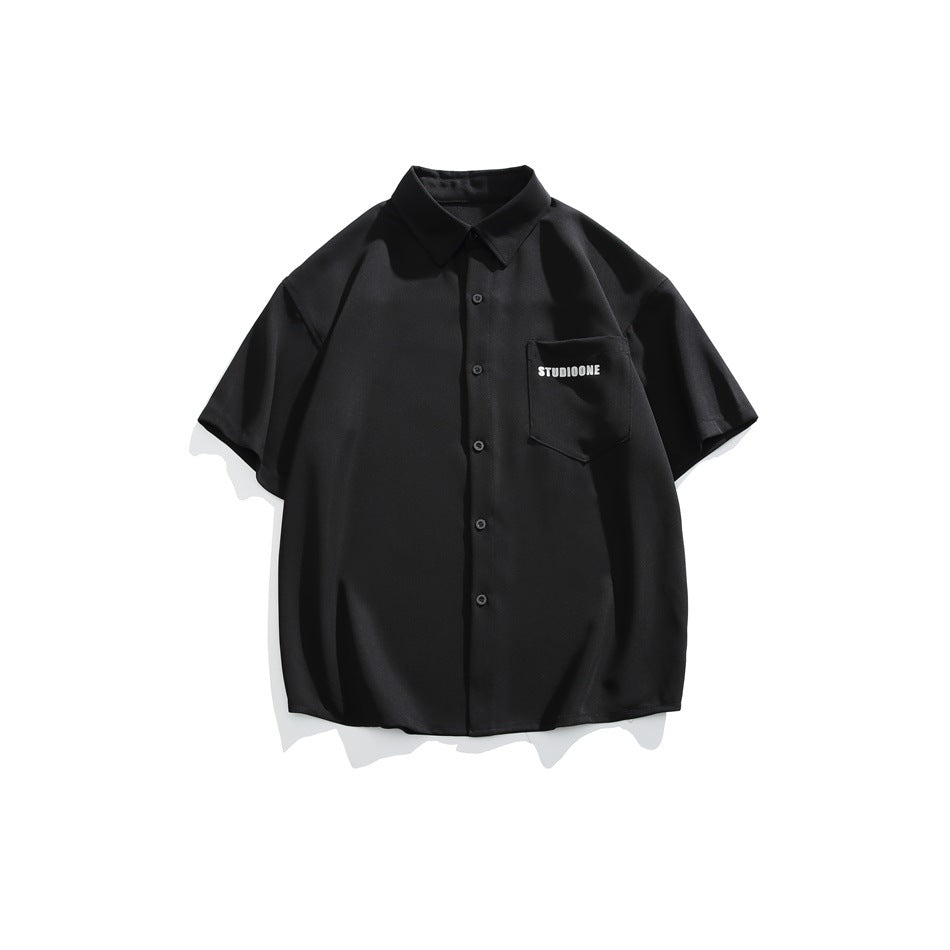 Front view of a black short-sleeve button-up shirt with a collar and a chest pocket with small white lettering