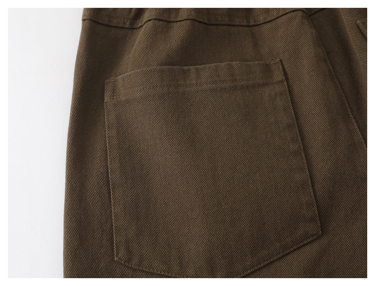 Close-up of a large patch pocket on the back of brown trousers.