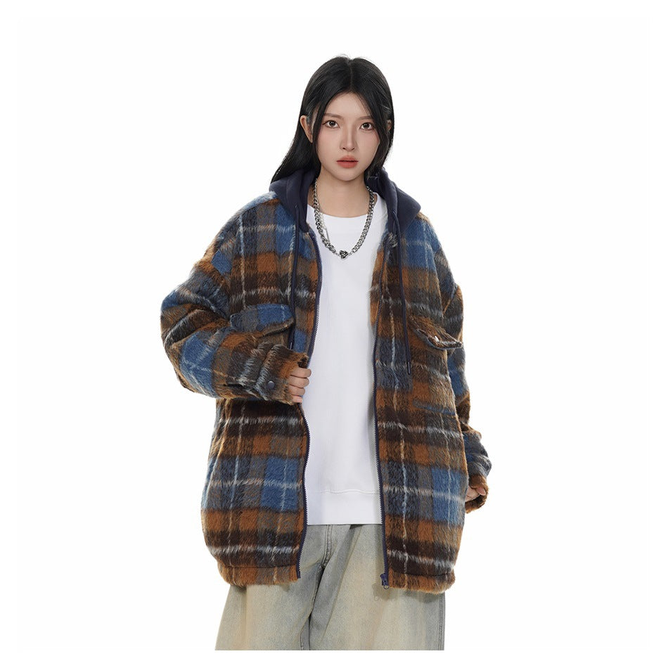 Model wearing an open brown and blue plaid hooded jacket with navy hood over a white top and light wide-leg jeans