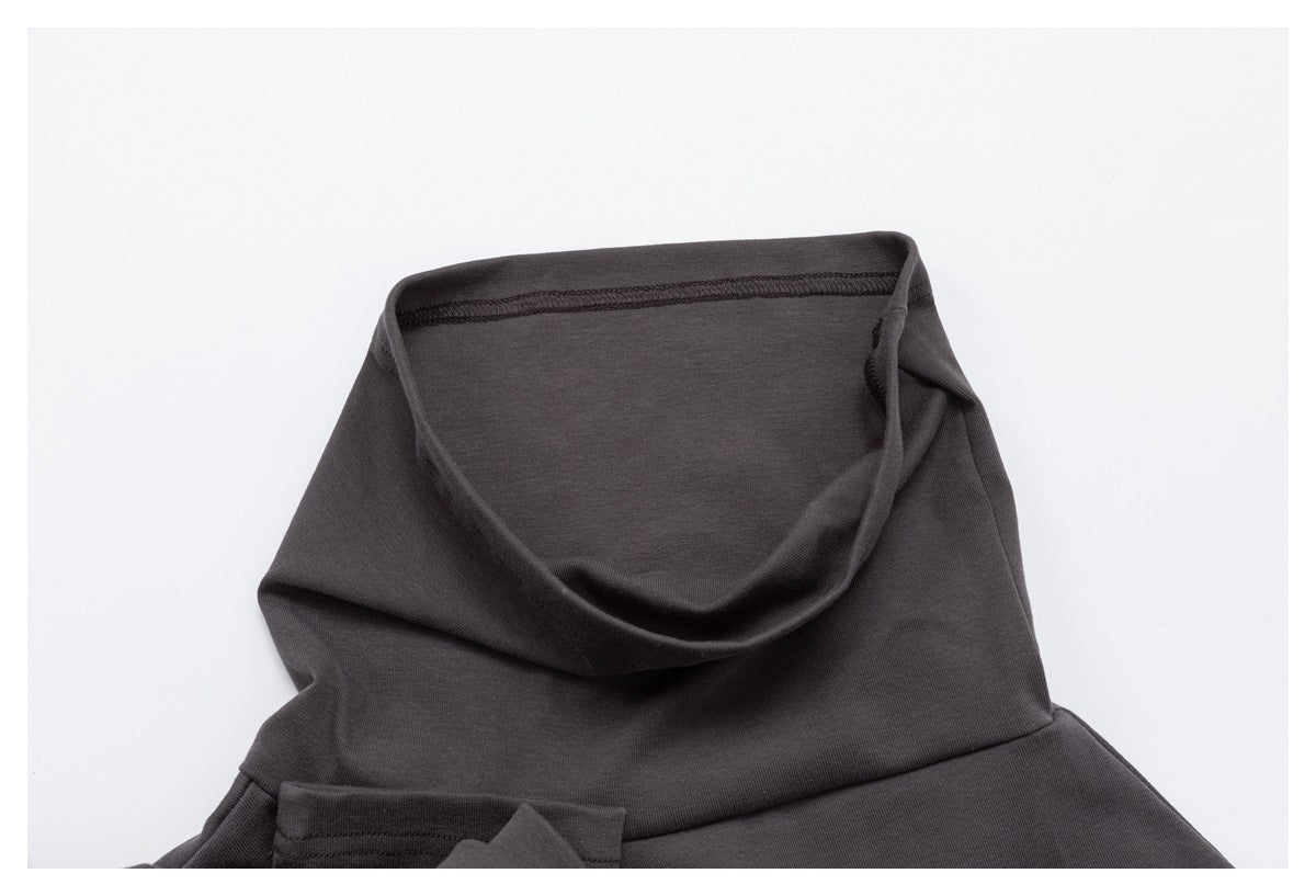 Close-up of the charcoal top's draped high neckline and inside seam.