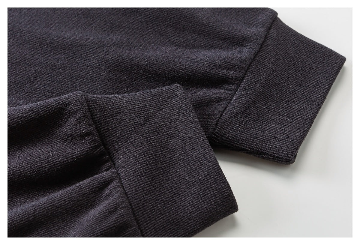Close-up of dark charcoal sleeves with wide ribbed cuffs and stitched edges.