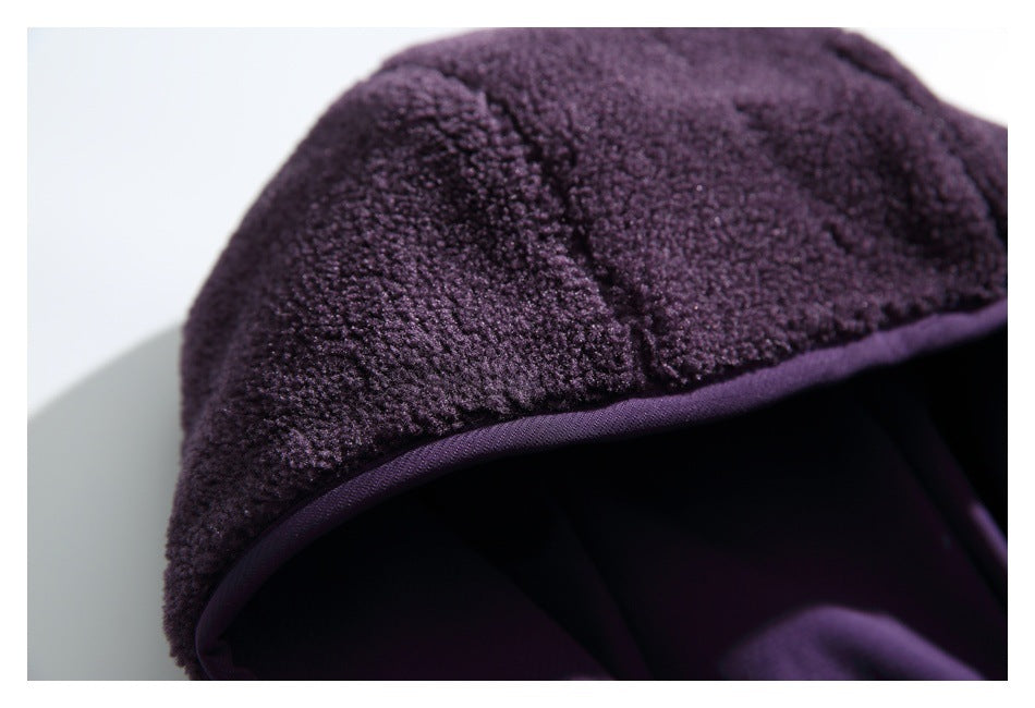 Macro view of the dark purple jacket's plush fleece hood and smooth purple edging.