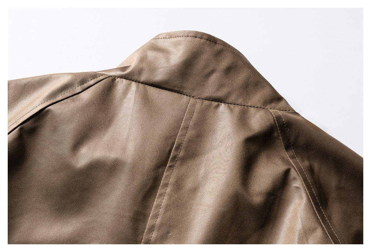 Close-up of a taupe-brown jacket collar and shoulder seams on a light background.