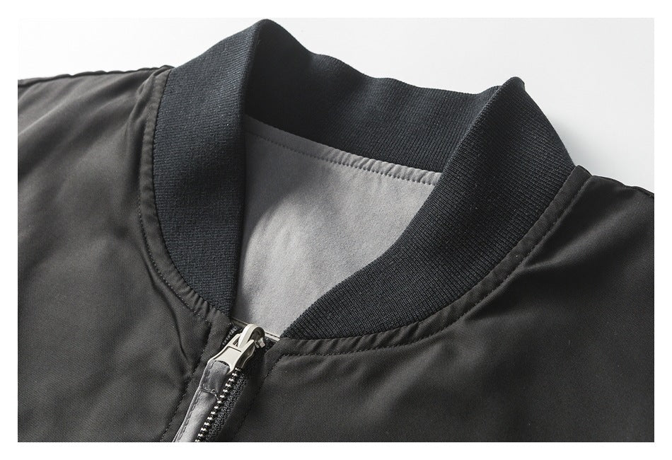Close-up of the black bomber jacket's ribbed collar, inner lining, and metal front zipper.