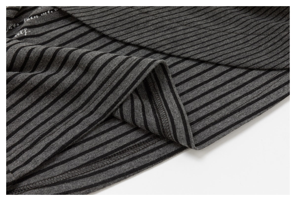 Close-up of charcoal-gray and black striped knit fabric, showing a folded edge and stitched seam.