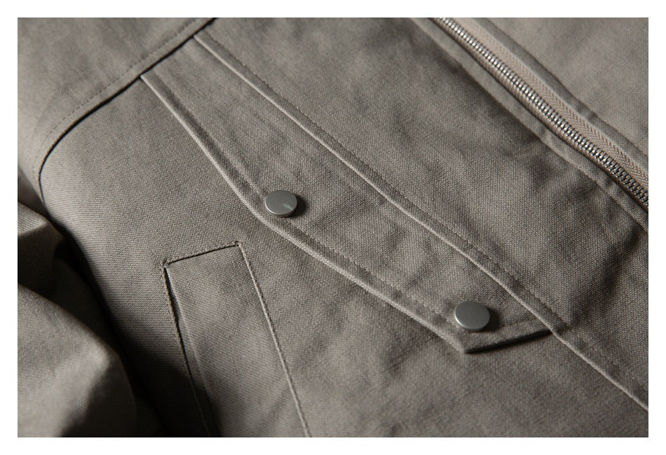 Close-up of the taupe-gray jacket's front zipper, snap-button placket, and rectangular pocket.