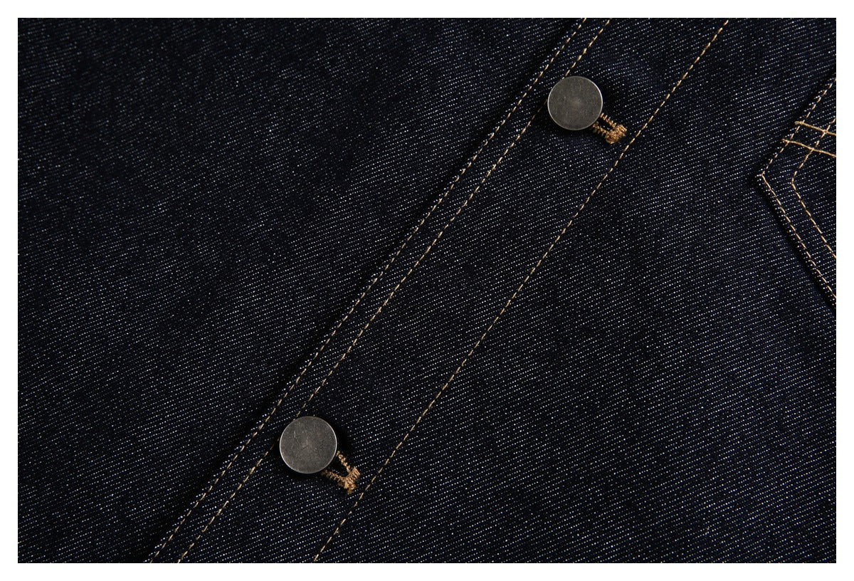 Close-up of a dark denim button placket with two metal buttons and contrasting tan stitching.