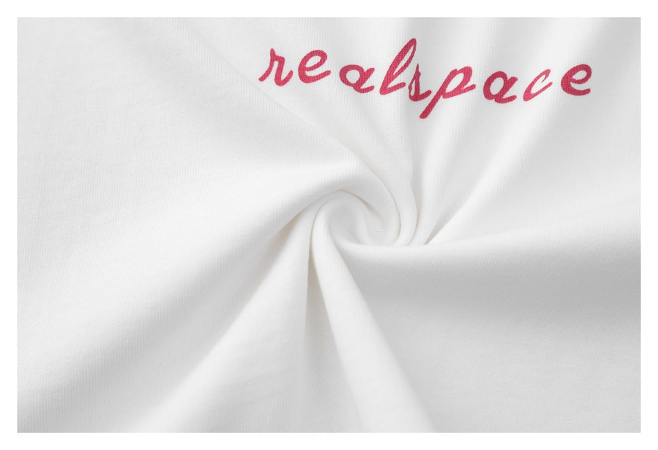 Close-up of pink “realspace” lettering printed on white T-shirt fabric.